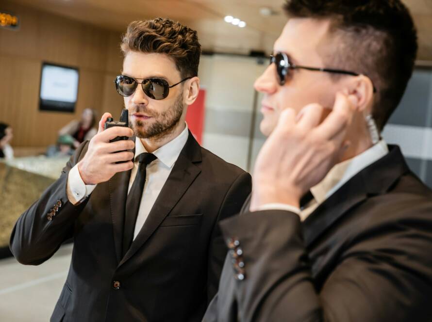 bodyguard service, private security, handsome man in sunglasses and formal wear communicating