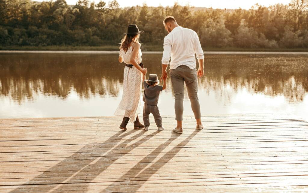Family standing on pier near lake