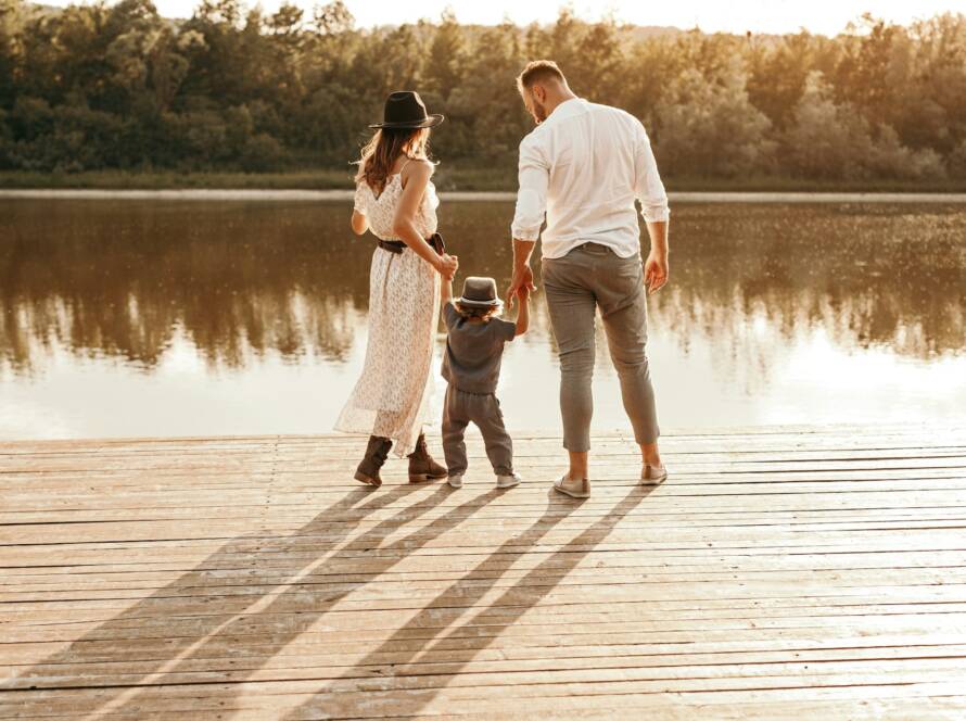 Familie steht am Pier in der Nähe des Sees